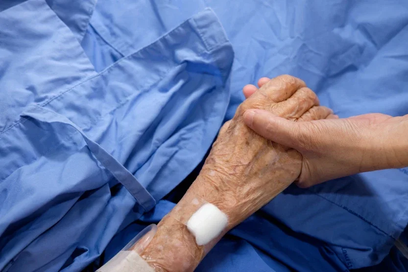 Caregiver holding elderly patient