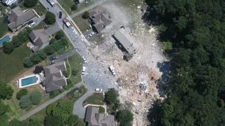 Aerial drone view of catastrophic house explosion debris field in a residential neighborhood for personal injury litigation