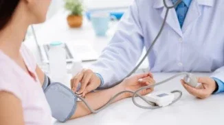 Doctor checking patient blood pressure during medical examination for injury assessment