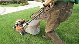 Person operating Husqvarna lawn mower representing defective power equipment personal injury lawsuit