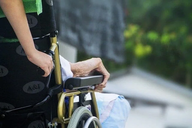 Caregiver assisting elderly patient in wheelchair representing nursing home negligence and elder injury claims
