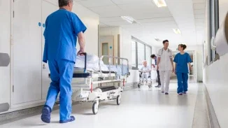 Hospital staff transporting patient on gurney through busy medical corridor in negligence injury case