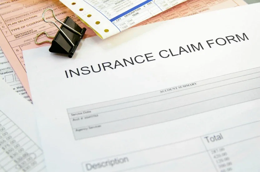 Insurance claim form on desk representing personal injury settlement and insurance coverage dispute