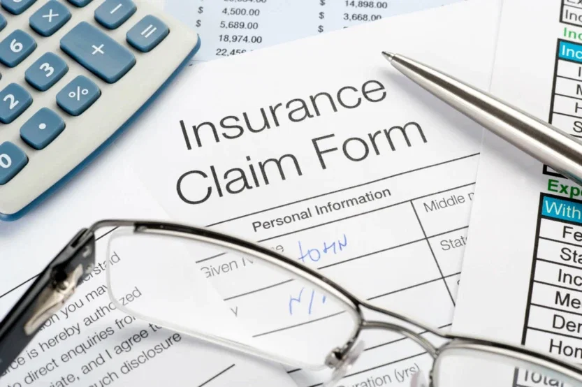 Insurance claim form with pen and calculator representing injury compensation and insurance bad faith litigation