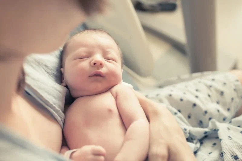 Newborn baby sleeping peacefully in parent