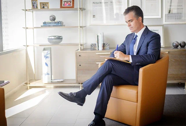 Matt Casey, partner at Ross Feller Casey, sitting in a chair at the office.