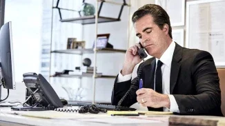 Matt Casey, Philadelphia medical malpractice attorney, on phone taking notes at office desk