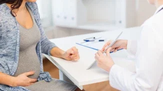 Pregnant woman consulting with OB-GYN physician during prenatal appointment relevant to birth injury malpractice claim