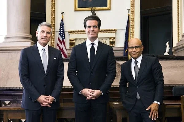 Three Ross Feller Casey personal injury attorneys standing together in formal courtroom setting with American flag