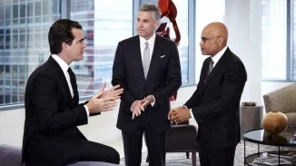 Three Philadelphia personal injury attorneys in dark suits consulting together in modern law office