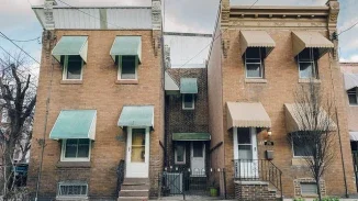 Row of brick Philadelphia rowhouses with awnings representing premises liability and slip and fall injury claims