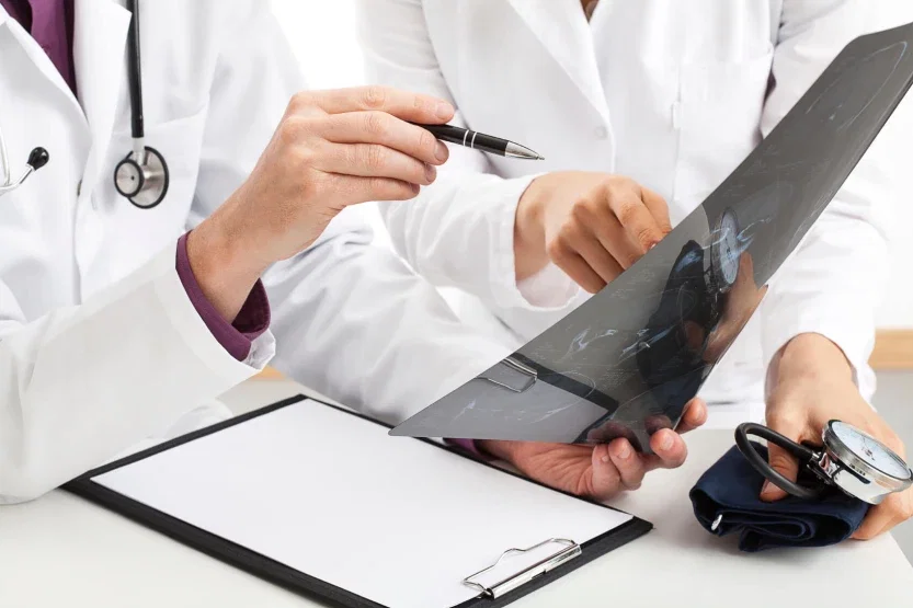 Two physicians in white coats reviewing X-ray imaging together in medical malpractice consultation setting