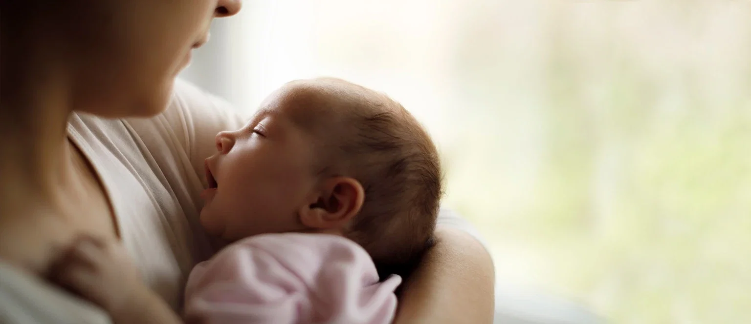 Mother cradling a sleeping newborn representing birth injury and medical negligence legal claims