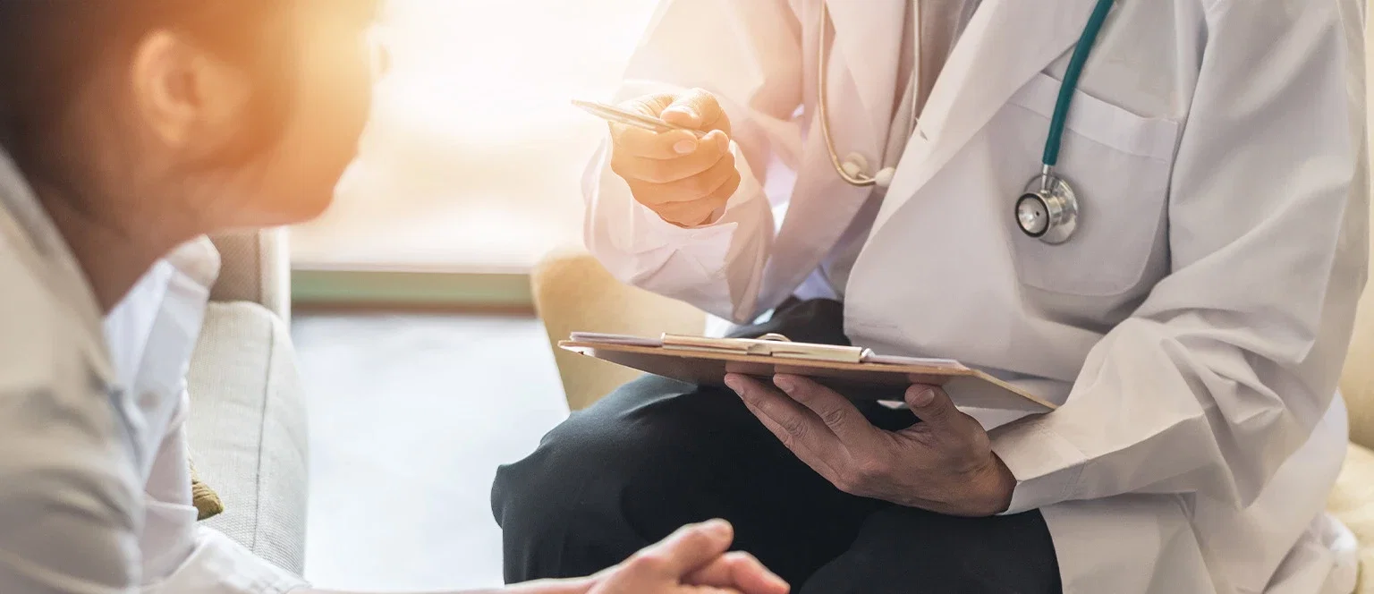 Doctor with stethoscope reviewing patient records during a cervical cancer diagnosis or misdiagnosis consultation