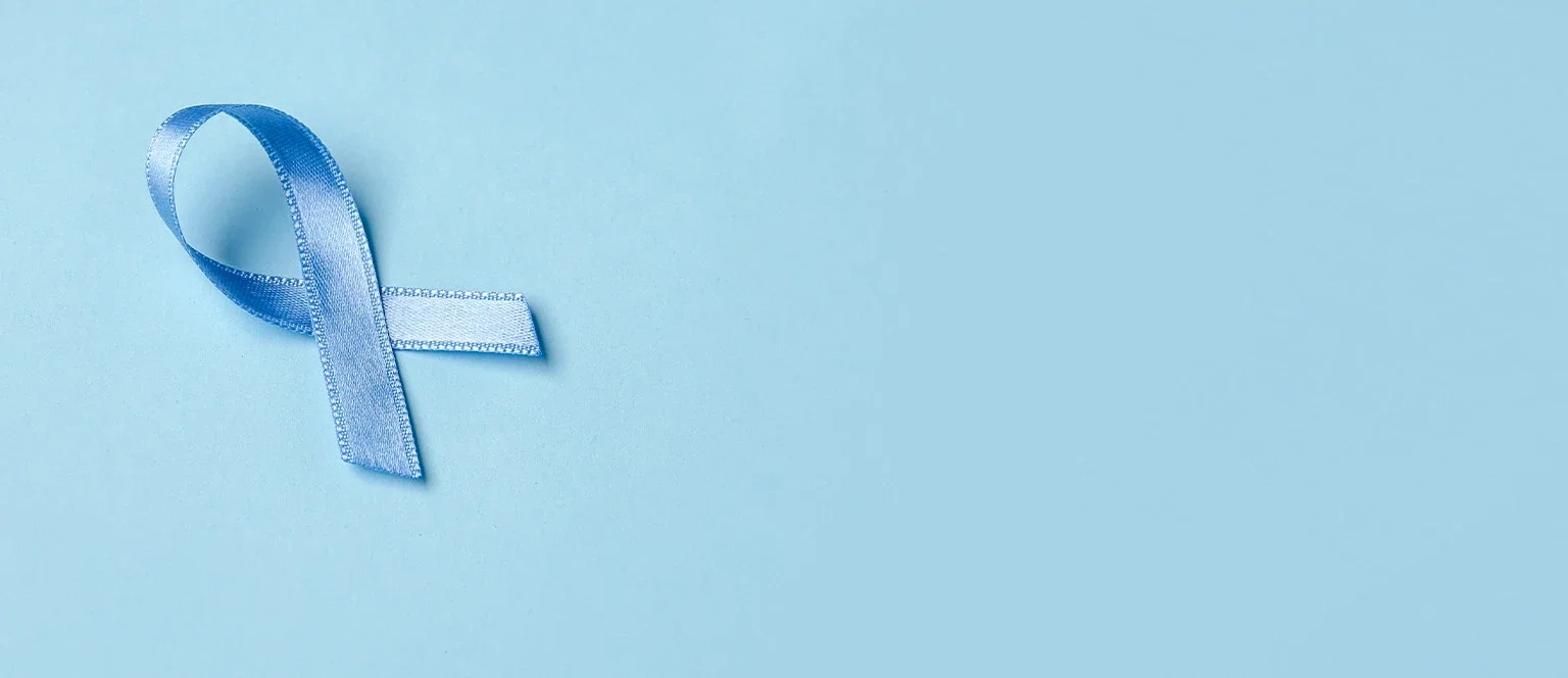 Blue awareness ribbon on a light blue background representing colon cancer misdiagnosis injury claims