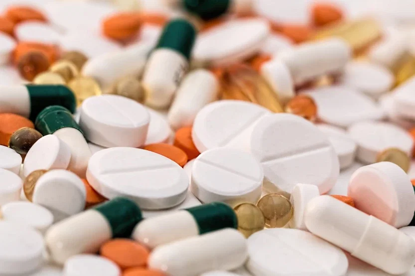 Assorted prescription medication tablets and capsules in multiple colors representing defective drug personal injury claims