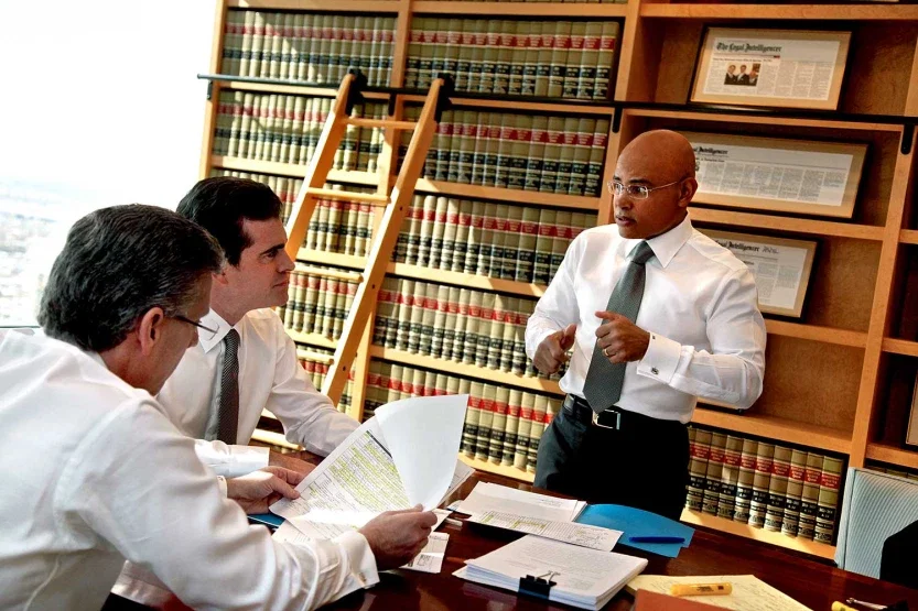 Ross Feller Casey personal injury attorney presenting case argument to colleagues in front of wall of legal volumes