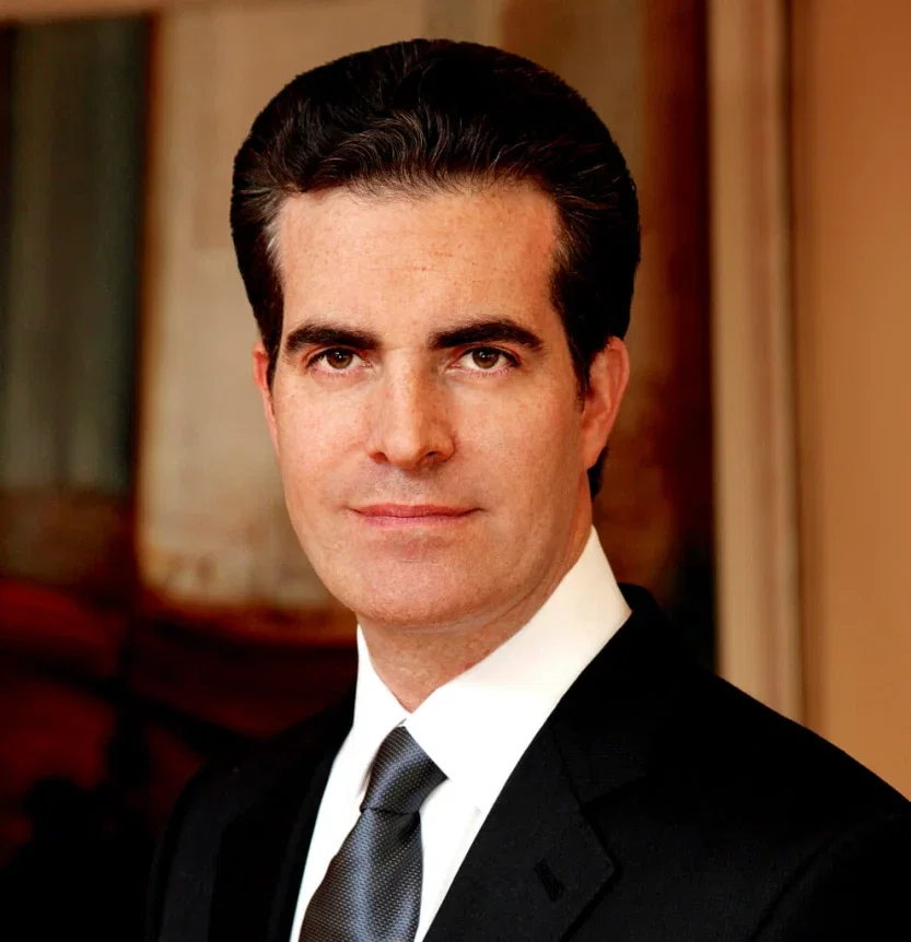 Tight close-up professional headshot of personal injury attorney in dark suit against soft-focus office background