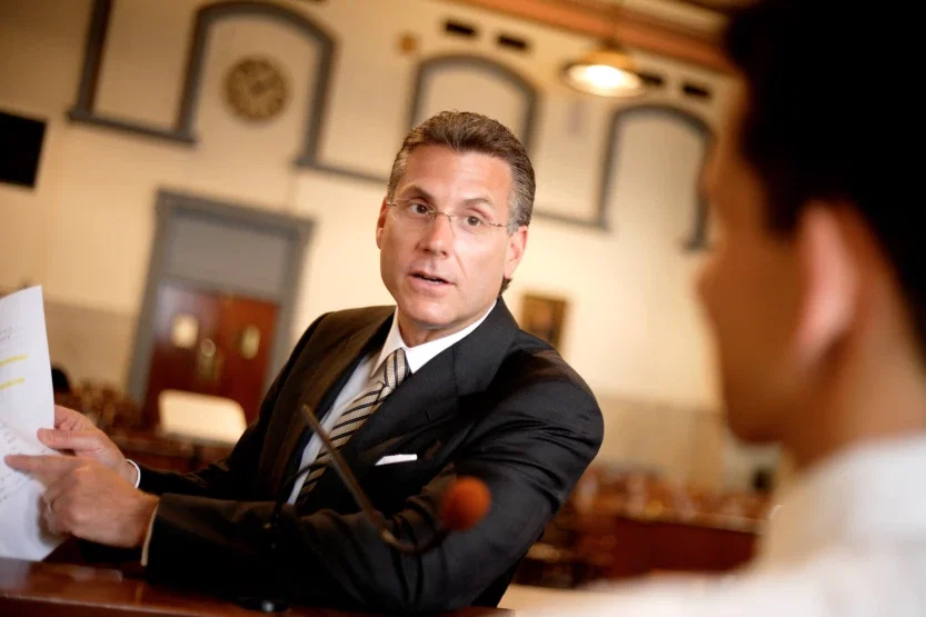 Personal injury trial attorney referencing legal paperwork while addressing opposing counsel in court