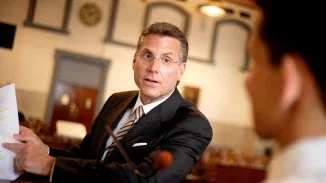 Personal injury trial attorney referencing legal paperwork while addressing opposing counsel in court