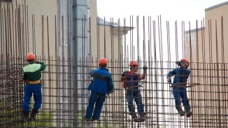 Construction workers in hard hats assembling steel rebar framework on a worksite injury claim