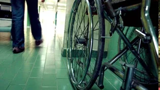 Empty wheelchair in hospital hallway representing serious personal injury resulting in long-term disability